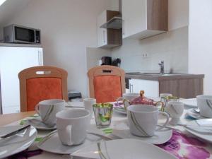 a table with cups and saucers on it in a kitchen at Janos-Ferienwohnung-2 in Friedrichsbrunn