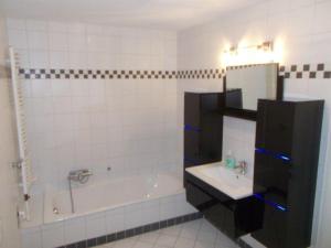 La salle de bains blanche est pourvue d'une baignoire et d'un lavabo. dans l'établissement Janos-Ferienwohnung-2, à Friedrichsbrunn