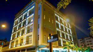 a yellow building with a street sign in front of it at Othello Hotel in Mersin