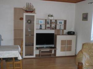 a living room with a computer monitor on a shelf at Ferienwohnung-Marita in Carolinensiel