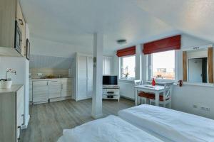 ヴェニングシュテットにあるHaus Brönshoog, Appartement 11 in strandnaher Lageのベッドルーム1室(ベッド1台、テーブル付)、キッチン