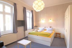 - une chambre avec un lit avec un chien assis dans l'établissement Kapitaenshaus-Lassen-Zimmer-Amistad, à Westerland