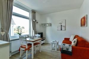 - un salon avec une table, un canapé et un bureau dans l'établissement App-7-in-strandnaher-Lage-Baederstil-Villa-in-Wenningstedt-Sylt, à Wenningstedt