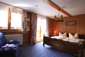 a bedroom with a bed and a couch and windows at Alter-Kaiserhof in Bernau im Schwarzwald