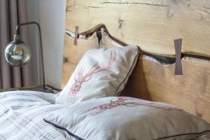 a bed with a wooden head board and a pillow at Sunny Apartment Maria Alm in Maria Alm am Steinernen Meer