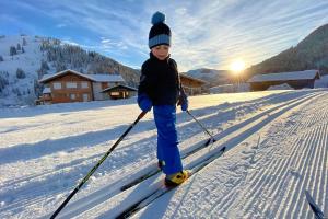 małe dziecko stoi na nartach w śniegu w obiekcie Sunny Apartment Maria Alm w mieście Maria Alm am Steinernen Meer