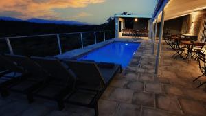 a swimming pool on a patio with chairs and a table at Rooiberg Wild Private Game Reserve in Ladismith