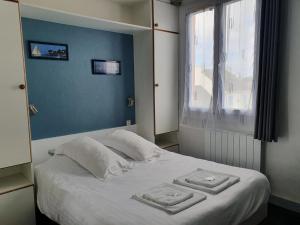 a bedroom with a bed with two towels on it at Hôtel Glann Ar Mor in Arzon