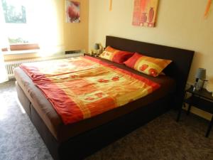 ein Schlafzimmer mit einem großen Bett mit einer Decke darauf in der Unterkunft  Ferienwohnung im Teutoburger Wald in Schieder-Schwalenberg