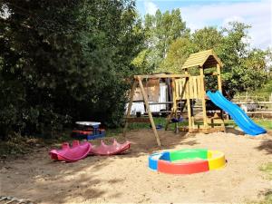 einen Spielplatz mit Rutsche und Spielgeräten im Sand in der Unterkunft Appartement 2a - Seepferdchen in Timmendorfer Strand