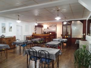 a restaurant with tables and chairs in a room at Hôtel Glann Ar Mor in Arzon