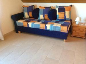 1 dormitorio con cama azul y mesa de madera en Goldene-Linie-4-Deichblick, en Wangerland