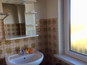 a bathroom with a sink and a mirror and a window at Goldene-Linie-4-Deichblick in Wangerland