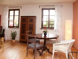 ein Esszimmer mit einem Holztisch und Stühlen in der Unterkunft Altstadt Ferienwohnung Torgau in Torgau