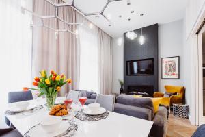 a living room with a white table with flowers on it at Z14 Boutique Residence - Krakow Old Town in Kraków