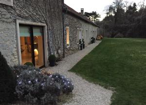 a stone building with a walkway next to a yard at Domaine des Grattières in Hermonville