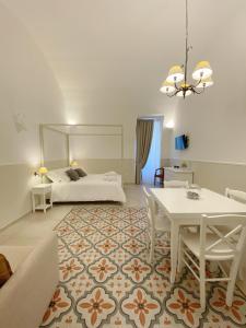 a living room with a bed and a table and a dining room at Domina Living Apartments - Montecucco in Bisceglie