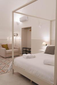 a white bedroom with a bed and a couch at Domina Living Apartments - Montecucco in Bisceglie