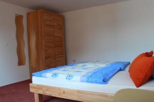 Schlafzimmer mit einem Bett und einem Holzschrank in der Unterkunft CHRISTEL´S  Ferienwohnung in Badenweiler