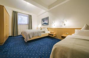 Łóżko lub łóżka w pokoju w obiekcie Arlen Lodge Hotel inkl Premium Karte im Sommer