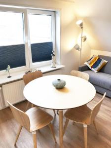 ヘルヌムにあるFerienwohnung-LEEのリビングルーム(白いテーブル、椅子付)