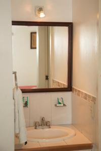 a bathroom with a sink and a mirror at Hotel Arrecife Chachalacas in Chachalacas