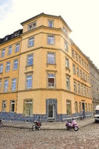 ein großes gelbes Gebäude mit zwei davor geparkt in der Unterkunft 3 Raum Fewo Dresden Zentrum - Balkon Blick auf Altstadt - L10 in Dresden