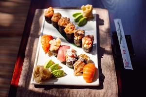 a plate of sushi and vegetables on a table at Parade Hotel Yaroslavl in Yaroslavl