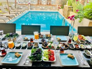 een tafel met borden eten naast een zwembad bij Livia Garden Hotel in Selcuk