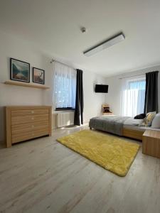 - une grande chambre avec un lit et un tapis jaune dans l'établissement Apartamenty Zielony Ogród, à Szczyrk