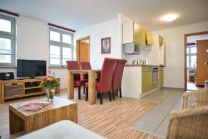 eine Küche und ein Wohnzimmer mit einem Tisch und Stühlen in der Unterkunft Zum Goldenen Anker in Stralsund