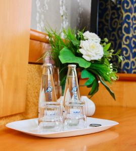 a plate with two glasses and a vase of flowers at Parkhotel Viktoria in Velten