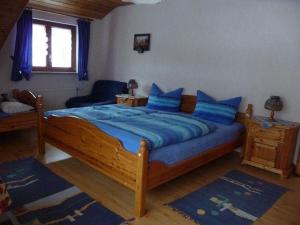 ein Schlafzimmer mit einem großen Holzbett mit blauen Kissen in der Unterkunft Ferienwohnung Nr.1 in Vöhrenbach