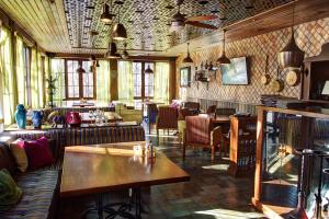 - un restaurant avec des tables et des chaises dans une salle dans l'établissement Parade Hotel Yaroslavl, à Yaroslavl