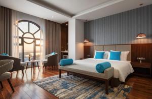 een slaapkamer met een groot bed met blauwe kussens bij D'Lecia Ha Long Hotel in Ha Long