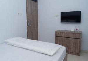 a bedroom with a bed and a flat screen tv at hotel padma tangerang in Tangerang