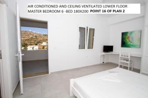 een witte kamer met een bed en een raam bij Aegean Dream 2 in Panteli