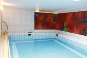 una gran piscina con azulejos azules en la pared en Haus-Meisennest-Wohnung-Meise, en Westerland