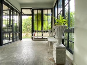 a conservatory with a table and chairs and a vase at Mosstel in Phitsanulok