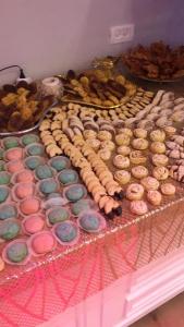 una mesa cubierta con rosquillas de diferentes colores y otros alimentos en King Koresh Hotel, en Netanya