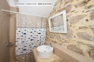 een badkamer met een wastafel en een spiegel bij Aegean Dream 2 in Panteli +19 foto's