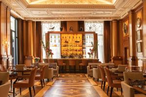 a restaurant with tables and chairs and a bar at Palazzo Parigi Hotel & Grand Spa - LHW in Milan