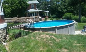 a swimming pool in a yard next to a fence at Boothie Manor in Davenport