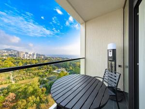 a table and chair on a balcony with a view at Апарт-отель МЕТРОПОЛЬ in Sochi