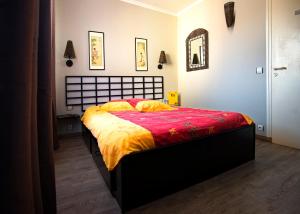 a bedroom with a bed with a red and yellow blanket at LA CHINOISERIE in Binson-et-Orquigny