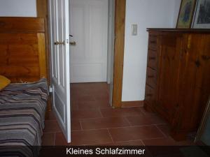UlsnisにあるFerienhaus-Krohn-Schleiblickのベッドルーム1室(ベッド1台、木製ドレッサー付)