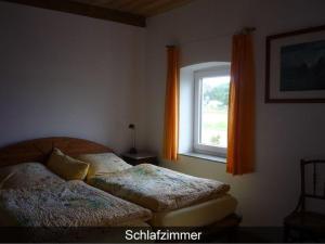 2 Betten in einem Schlafzimmer mit Fenster in der Unterkunft Ferienhaus Krohn Schleiblick in Ulsnis