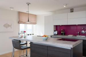 a kitchen with a counter with a sink and purple at Sylter-Juwel-mit-Traumblick in Westerland