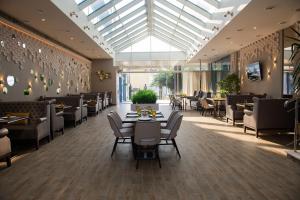 un restaurante con mesas y sillas y techo de cristal en Hotel El Paraiso, en Adler