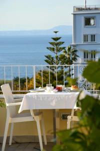 a white table and chairs on a balcony with the ocean at Hotel Crawford in Sant'Agnello